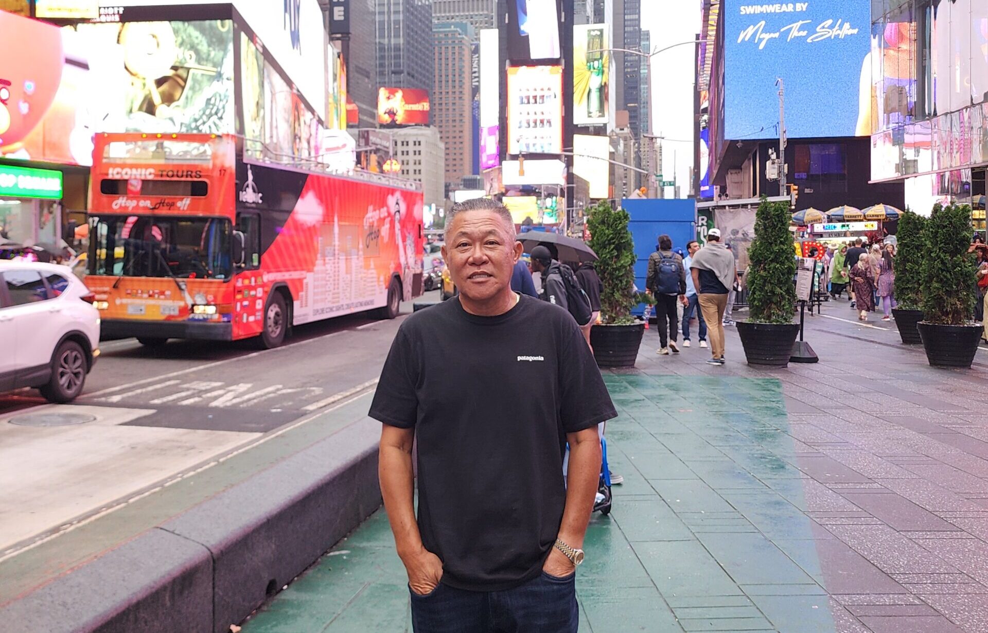 Sae Joon Park stands on in New York's Times Square wearing a dark T-shirt, his hands in his pockets.