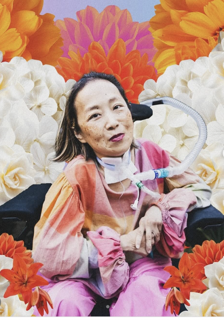 Alice Wong sits in a chair, wearing a pink and multicolored outfit, with a ventilator tube attached. She is surrounded by dense layers of large flowers in shades of orange, pink, and white, forming a vibrant, collage-style background.