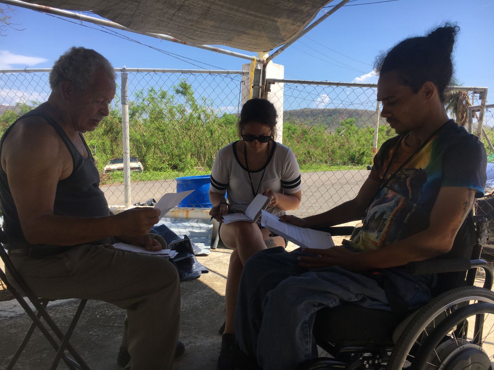 A group of disaster relief experts, one who uses a wheelchair, sit planning how to tackle a climate disaster.
