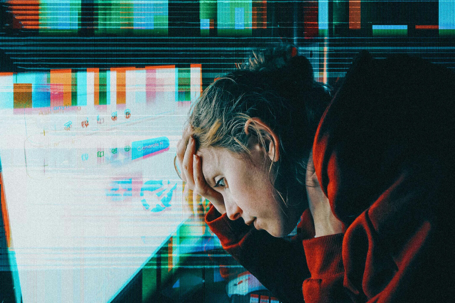 Image of a person, head in their hands, looking at a failing computer screen