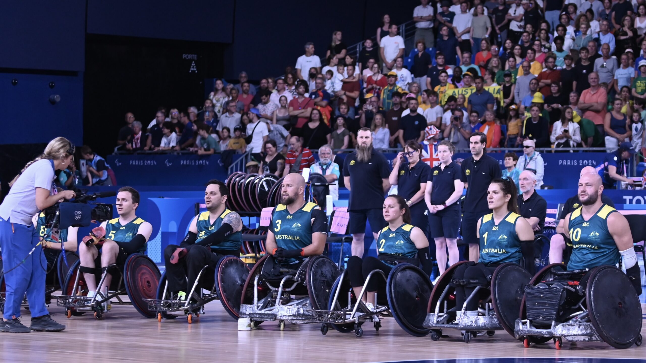 Image of the Australian Wheelchair Rugby team at the 2024 Paralympics in their trademark green and gold uniforms.